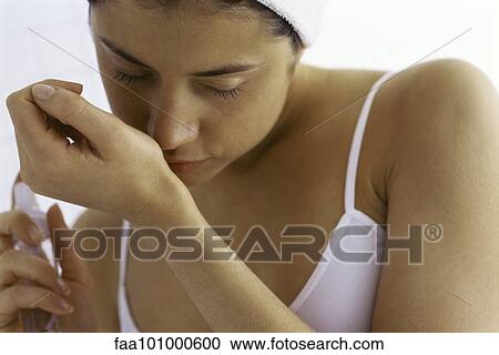 Young woman trying on perfume View Large Photo Image Stock Image - Young woman trying on perfume. Fotosearch