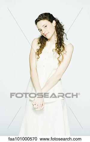 "Young woman with hands clasped in front of her, smiling, portrait" View Large Photo Image Stock Image - "Young woman with hands clasped in front of her, smiling, portrait". Fotosearch