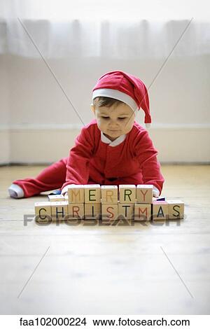 "Baby boy dressed as Santa Claus with toy blocks reading ""Merry Christmas""" View Large Photo Image Picture - "Baby boy dressed as Santa Claus with toy blocks reading ""Merry Christmas""". Fotosearch