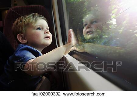 Baby boy gazing out train window in awe View Large Photo Image Stock Image - Baby boy gazing out train window in awe. Fotosearch
