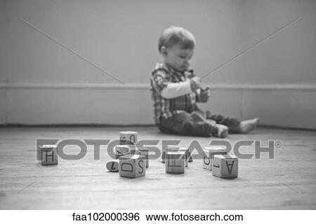 Baby boy playing on floor in nursery View Large Photo Image Stock Photograph - Baby boy playing on floor in nursery. Fotosearch