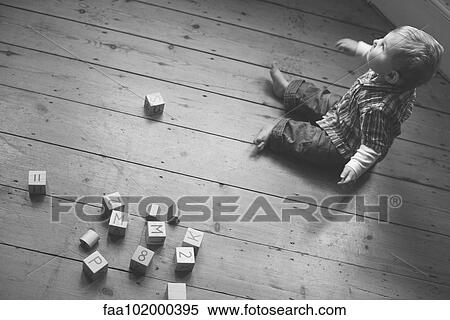 Baby boy sitting on nursery floor with wooden blocks View Large Photo Image Stock Photography - Baby boy sitting on nursery floor with wooden blocks. Fotosearch