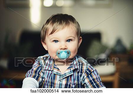 Picture - "Baby boy with pacifier in his mouth, portrait". Fotosearch