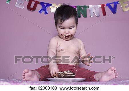 Stock Photo - Baby eating birthday cake. Fotosearch