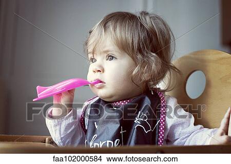Baby girl feeding herself View Large Photo Image Picture - Baby girl feeding herself. Fotosearch