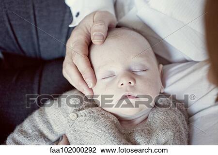Stock Image - Baby sleeping on mother's lap. Fotosearch