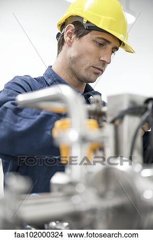 Blue-collar worker at work in factory View Large Photo Image Picture - Blue-collar worker at work in factory. Fotosearch