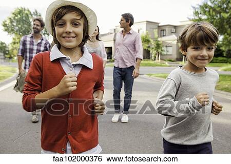 "Boys running outdoors, family in background" View Large Photo Image Stock Photograph - "Boys running outdoors, family in background". Fotosearch