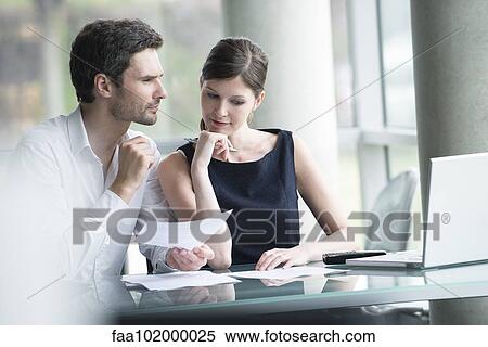 Stock Photography - Business associates brainstorming. Fotosearch