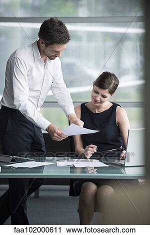 Stock Image - Businessman explaining document to colleague. Fotosearch