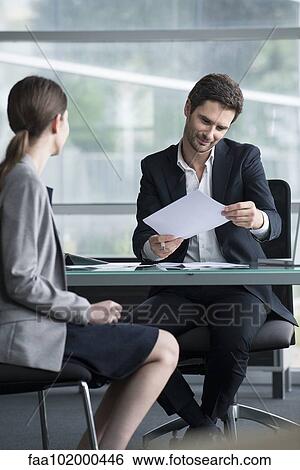 Businessman reviewing document with client View Large Photo Image Stock Photograph - Businessman reviewing document with client. Fotosearch
