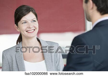 Stock Photograph - Businesswoman chatting with colleague. Fotosearch