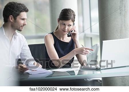 Businesswoman directing colleague's attention to computer screen View Large Photo Image Picture - Businesswoman directing colleague's attention to computer screen. Fotosearch