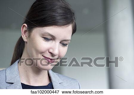 "Businesswoman looking down in thought, smiling" View Large Photo Image Stock Photo - "Businesswoman looking down in thought, smiling". Fotosearch