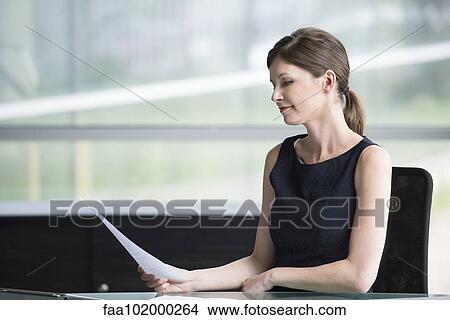Businesswoman reviewing document View Large Photo Image Picture - Businesswoman reviewing document. Fotosearch