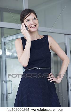 Stock Photography - "Businesswoman talking on cell phone, smiling cheerfully". Fotosearch