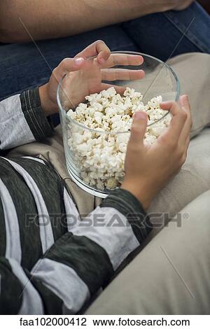 "Child holding bowl of popcorn on lap, cropped" View Large Photo Image Stock Image - "Child holding bowl of popcorn on lap, cropped". Fotosearch