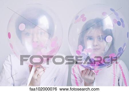 Stock Photograph - Children hiding behind transparent balloons. Fotosearch