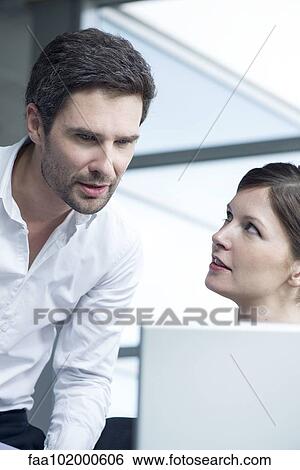 Colleagues collaborating in office View Large Photo Image Stock Photograph - Colleagues collaborating in office. Fotosearch