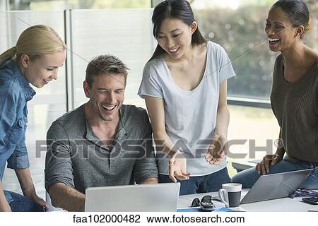 Stock Image - Colleagues collaborating on project. Fotosearch