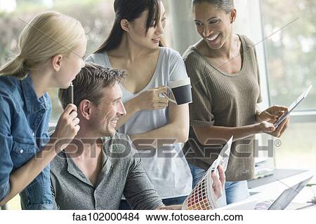 Colleagues having lighthearted time while browsing color swatch catalog View Large Photo Image Picture - Colleagues having lighthearted time while browsing color swatch catalog. Fotosearch