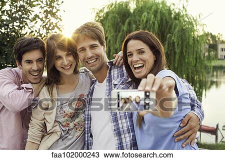 Stock Image - College friends taking group selfie. Fotosearch