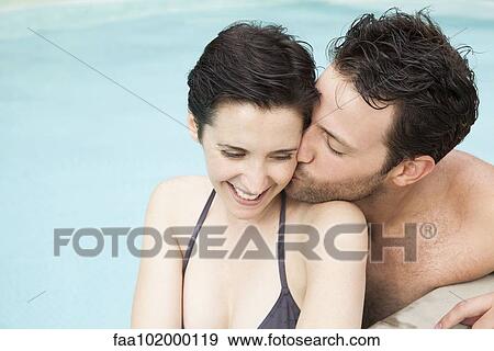 "Couple relaxing in pool, man kissing woman's cheek" View Large Photo Image Stock Photo - "Couple relaxing in pool, man kissing woman's cheek". Fotosearch