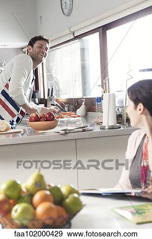 Couple talking together in kitchen View Large Photo Image Stock Photo - Couple talking together in kitchen. Fotosearch