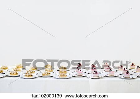 Dessert pastries lined up on table View Large Photo Image Stock Photo - Dessert pastries lined up on table. Fotosearch