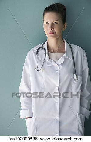 Stock Photograph - "Doctor leaning against wall, portrait". Fotosearch