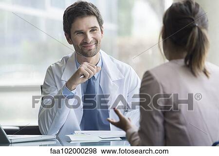 Doctor listening to patient express concerns during consultation View Large Photo Image Stock Photo - Doctor listening to patient express concerns during consultation. Fotosearch