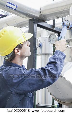 Stock Photo - Engineer working on industrial equipment. Fotosearch