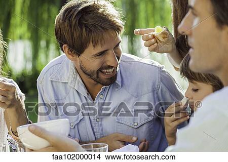 Family enjoying breakfast together outdoors View Large Photo Image Picture - Family enjoying breakfast together outdoors. Fotosearch