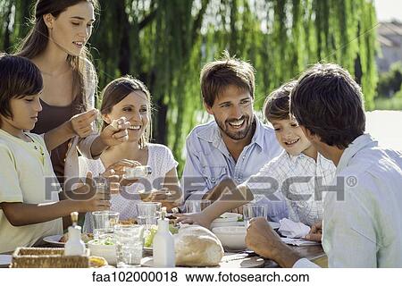Family enjoying breakfast together outdoors View Large Photo Image Stock Photo - Family enjoying breakfast together outdoors. Fotosearch