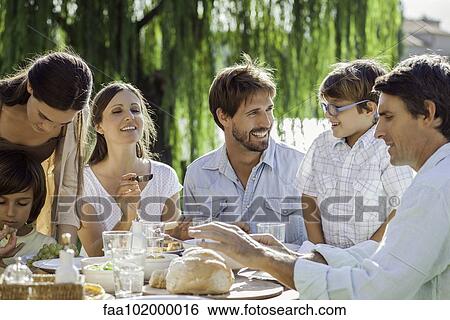 Family enjoying breakfast together outdoors View Large Photo Image Stock Photograph - Family enjoying breakfast together outdoors. Fotosearch