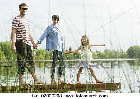 "Family holding hands on dock, portrait" View Large Photo Image Stock Photo - "Family holding hands on dock, portrait". Fotosearch