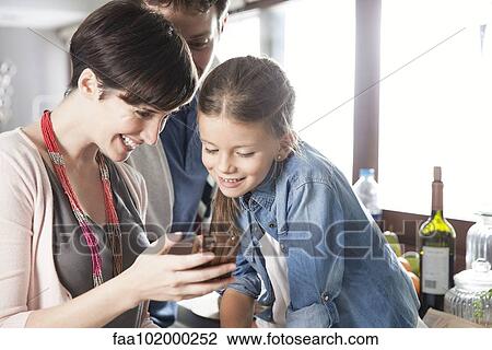 Family looking at smartphone together View Large Photo Image Stock Image - Family looking at smartphone together. Fotosearch