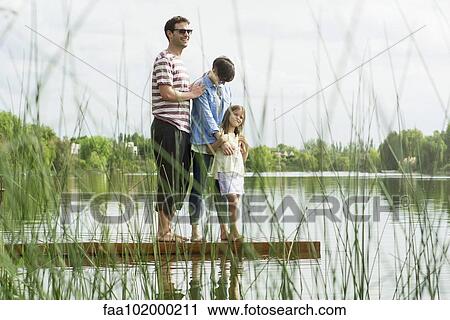 Stock Image - "Family standing on dock, portrait". Fotosearch