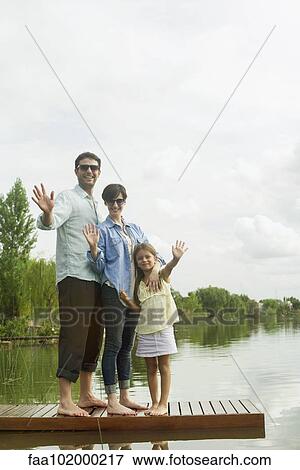 Family standing on dock waving View Large Photo Image Stock Photo - Family standing on dock waving. Fotosearch