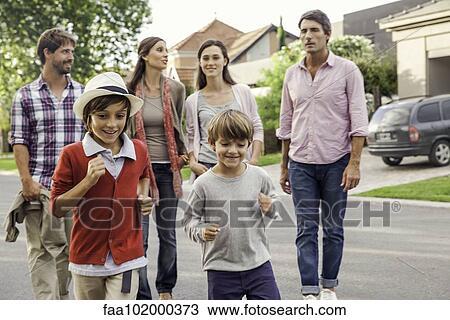 Family walking together through suburban neighborhood View Large Photo Image Stock Image - Family walking together through suburban neighborhood. Fotosearch
