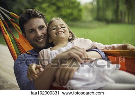Stock Image - Father and daughter together in hammock. Fotosearch