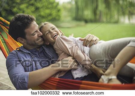 Stock Image - Father and daughter together in hammock. Fotosearch