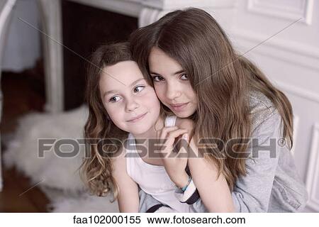 "Girl embracing younger sister, portrait" View Large Photo Image Stock Photography - "Girl embracing younger sister, portrait". Fotosearch