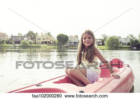 Stock Image - Girl kayaking on lake. Fotosearch
