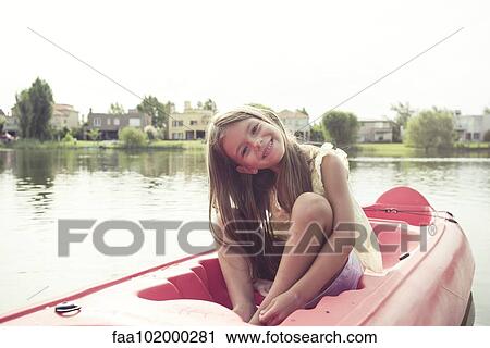 Stock Image - Girl kayaking on lake. Fotosearch
