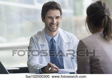 Stock Image - Healthcare worker meeting with patient in office. Fotosearch