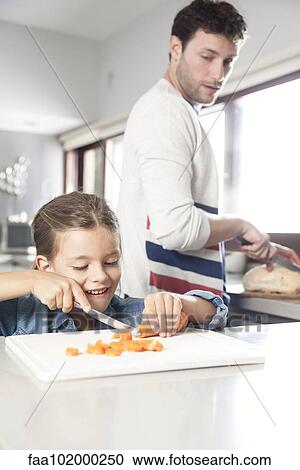 Little girl helping her father prepare food in kitchen View Large Photo Image Stock Image - Little girl helping her father prepare food in kitchen. Fotosearch