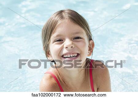 Stock Image - "Little girl in pool, smiling cheerfully, portrait". Fotosearch
