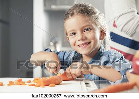 "Little girl slicing carrots in kitchen, portrait" View Large Photo Image Stock Photo - "Little girl slicing carrots in kitchen, portrait". Fotosearch