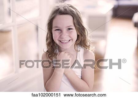 Stock Image - "Little girl smiling cheerfully, portrait". Fotosearch